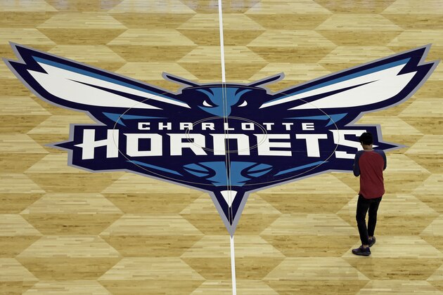 A photographer takes photos of the Charlotte Hornets logo during a news conference to unveil the design for their home court in Charlotte, N.C., Thursday, June 26, 2014. (AP Photo/Chuck Burton)