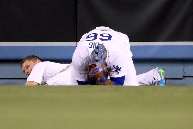 LOS ANGELES, CA - MAY 23:  Yasiel Puig #66 of the Los Angeles Dodgers reacts after colliding with Joc Pederson #31 after his catch for an out of Yadier Molina #4 of the St. Louis Cardinals to end the tenth inning at Dodger Stadium on May 23, 2017 in Los Angeles, California.  (Photo by Harry How/Getty Images)