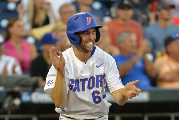 Florida's Ryan Larson celebrates after scoring on a two-run single by Josh Tobias during the fourth inning of an NCAA College World Series baseball game against Miami in Omaha, Neb., Saturday, June 13, 2015. Florida scored 11 runs in the fourth inning. (AP Photo/Ted Kirk)