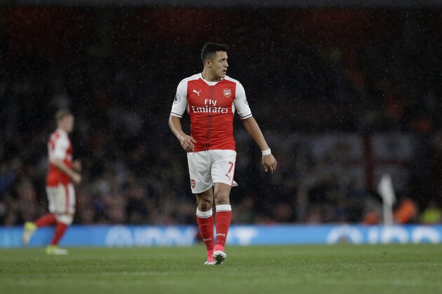 Arsenal's Alexis Sanchez walks in the rain during the English Premier League soccer match between Arsenal and Sunderland at the Emirates Stadium in London, Tuesday, May 16, 2017. (AP Photo/Matt Dunham)