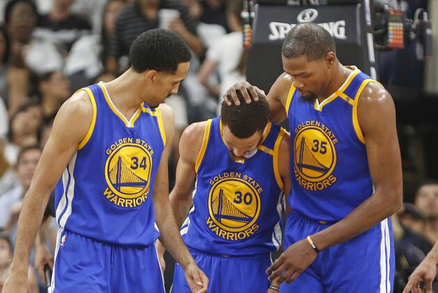 Golden State Warriors forward Kevin Durant (35) comes to the assistance of teammate Golden State Warriors guard Stephen Curry (30) after he was fouled during the second half in Game 3 of the NBA basketball Western Conference finals on Saturday, May 20, 2017, in San Antonio. On the left watching is Golden State Warriors guard Shaun Livingston (34). (AP Photo/Ronald Cortes)