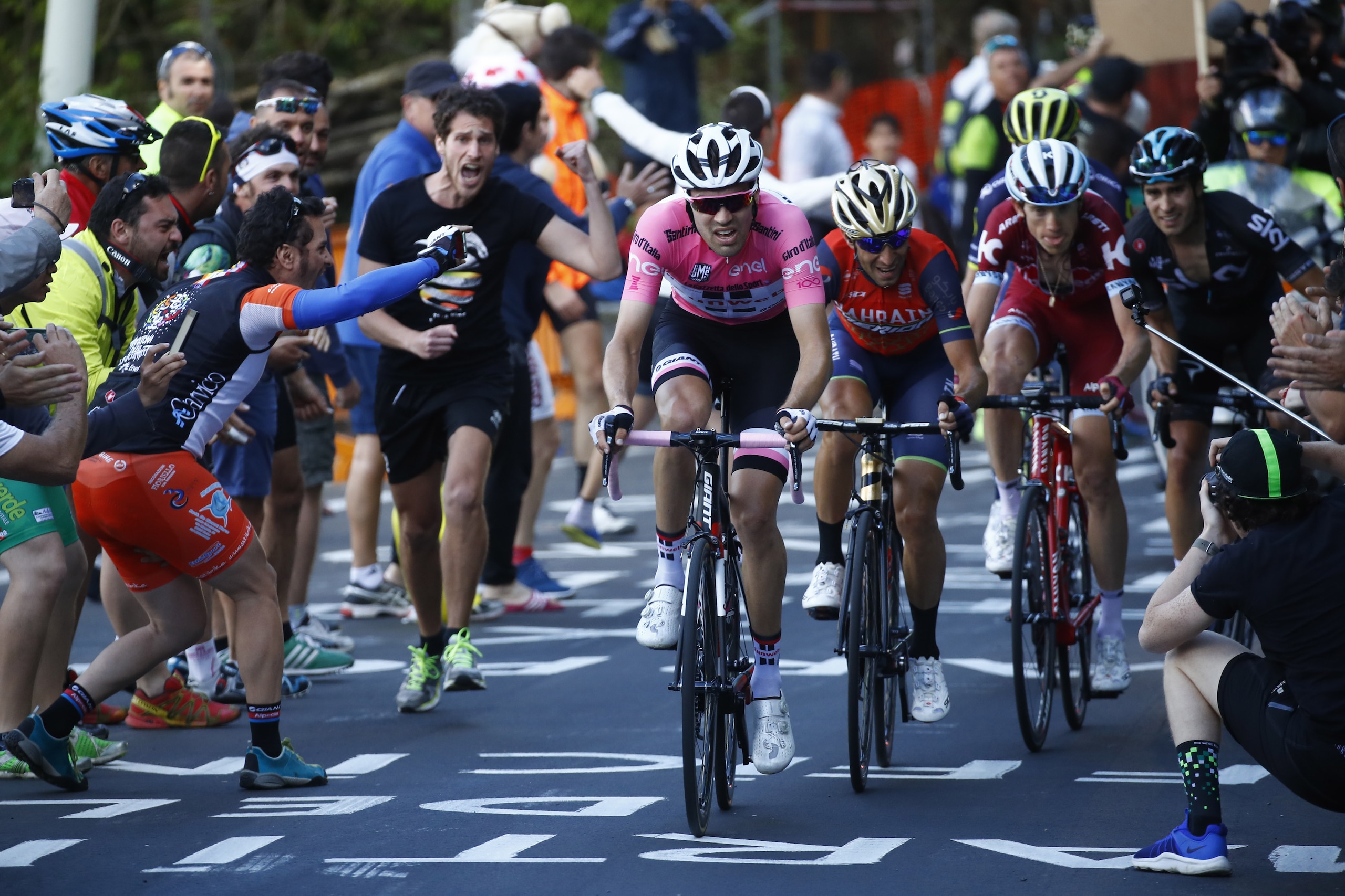 Cycling fans cheer Netherlands' Tom Dumoulin of team Sunweb riding ahead Italy's rider of team Bahrain - Merida Vincenzo Nibali (C) and Russia's Ilnur Zakarin (R) of team Katusha-Alpecin and Spain's Mikel Landa of team Sky during the 14th stage of the 100th Giro d'Italia, Tour of Italy, cycling race from Castellania to Oropa on May 20, 2017. 
Dutchman Tom Dumoulin further underlined his Giro d'Italia victory ambitions by beating Colombian rival Nairo Quintana to victory on Saturday's stage 14. Race leader Dumoulin, of the Sunweb team, finished 13 seconds ahead of Movistar climbing specialist Quintana at the summit of the 11.8km climb to Oropa to tighten his grip on the pink jersey.
 / AFP PHOTO / Luk BENIES        (Photo credit should read LUK BENIES/AFP/Getty Images)