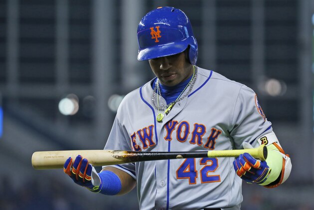 New York Mets' Yoenis Cespedes looks at his bat after lining out during the sixth inning of a baseball game against the Miami Marlins, Saturday, April 15, 2017, in Miami. (AP Photo/Wilfredo Lee)