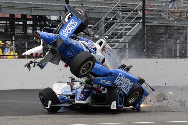 The car driven by Scott Dixon, of New Zealand, goes over the top of Jay Howard, of England, in the first turn during the running of the Indianapolis 500 auto race at Indianapolis Motor Speedway, Sunday, May 28, 2017, in Indianapolis. (AP Photo/Marty Seppala)