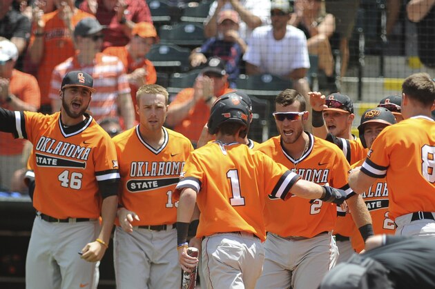 The Oklahoma State dugout celebrates with Ryan Cash (1) after he scores a run championship game in the Big 12 NCAA college baseball tournament in Oklahoma City, Sunday, May 28, 2017. (AP Photo/Kyle Phillips)