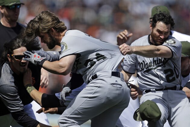 Washington Nationals' Daniel Murphy (20) tries to restrain teammate Bryce Harper (34) after Harper charged San Francisco Giants' Hunter Strickland after being hit with a pitch in the eighth inning of a baseball game Monday, May 29, 2017, in San Francisco. (AP Photo/Ben Margot)