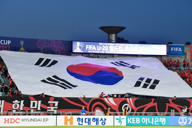 South Korea fans hold a giant national flag during the U-20 World Cup round of 16 football match between South Korea and Portugal in Cheonan on May 30, 2017. / AFP PHOTO / KIM Doo-Ho        (Photo credit should read KIM DOO-HO/AFP/Getty Images)