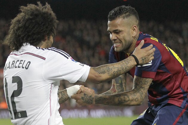 Barcelona's Dani Alves, right, helps Real Madrid's Marcelo get up after a tackle during a Spanish La Liga soccer match between FC Barcelona and Real Madrid at Camp Nou stadium, in Barcelona, Spain, Sunday, March 22, 2015. Barcelona won the match with a 2-1 score. (AP Photo/Emilio Morenatti)