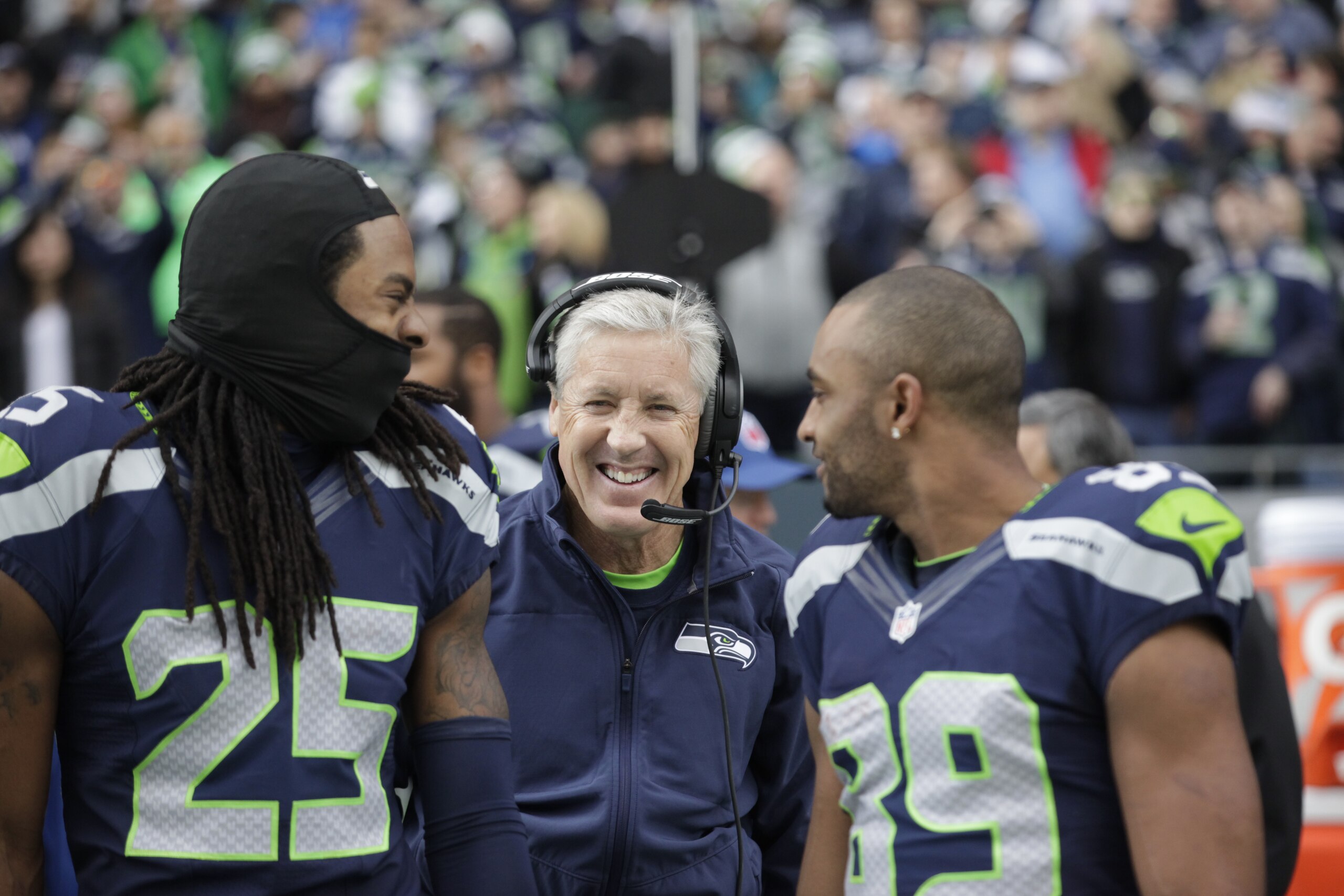 Seattle Seahawks head coach Pete Carroll, center, throws his arms around Richard Sherman (25) and Doug Baldwin before an NFL football game against the Arizona Cardinals, Sunday, Nov. 23, 2014, in Seattle. (AP Photo/Elaine Thompson)