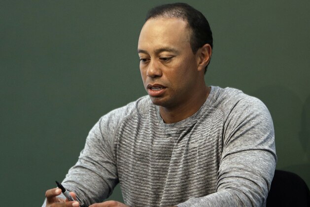 FILE - In this March 20, 2017, file photo, golfer Tiger Woods prepares to sign copies of his new book at a book signing in New York. Police say golf great Tiger Woods has been arrested on a DUI charge in Florida. The Palm Beach County Sheriff's Office says on its website that Woods was booked into a county jail around 7 a.m. on Monday, May 29, 2017. (AP Photo/Seth Wenig, File)