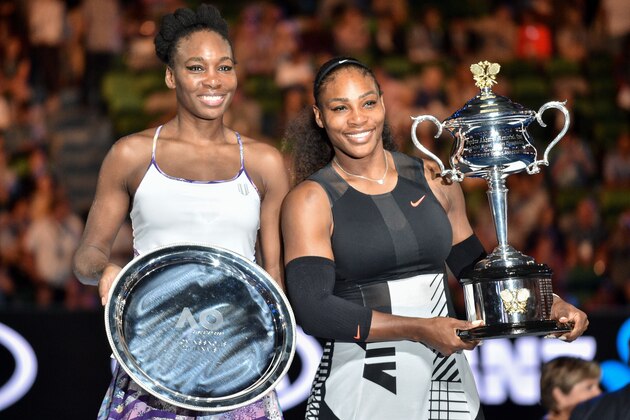 Serena Williams of the US (R) celebrates with the championship trophy during the awards ceremony after her victory against Venus Williams of the US in the women's singles final on day 13 of the Australian Open tennis tournament in Melbourne on January 28, 2017. / AFP / PETER PARKS / IMAGE RESTRICTED TO EDITORIAL USE - STRICTLY NO COMMERCIAL USE        (Photo credit should read PETER PARKS/AFP/Getty Images)