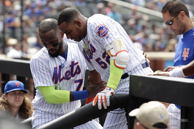 New York Mets' Jose Reyes (7) helps teammate Yoenis Cespedes (52) down the stairs into the dugout after Cespedes was injured during the fourth inning of a baseball game against the Atlanta Braves Thursday, April 27, 2017, in New York. (AP Photo/Frank Franklin II)