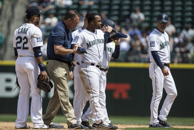 SEATTLE, WA - JUNE 1: Jean Segura #2, center, of the Seattle Mariners is helped from the field after injuring his ankle on a slide into second base during the fourth inning of a game against the Colorado Rockies at Safeco Field on June 1, 2017 in Seattle, Washington. The Rockies won the game 6-3. (Photo by Stephen Brashear/Getty Images)