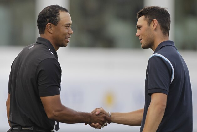 Tiger Woods, left, shakes hands with Germany's Martin Kaymer after the end of round one on the 18th hole during the  Dubai Desert Classic golf tournament at the Emirates Golf Club in Dubai, United Arab Emirates, Thursday Feb. 10, 2011. (AP Photo/Kamran Jebreili)