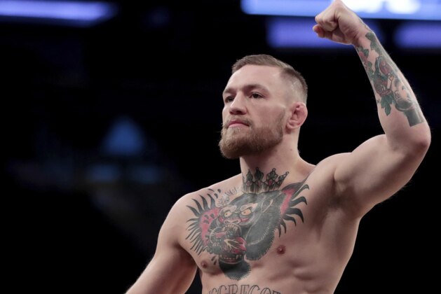 FILE - In this Nov. 9, 2016, file photo, Conor McGregor gestures toward fans while working out at Madison Square Garden in New York. McGregor has come to an agreement with UFC that has moved a proposed fight with Floyd Mayweather Jr. closer to reality. (AP Photo/Julio Cortez, File)