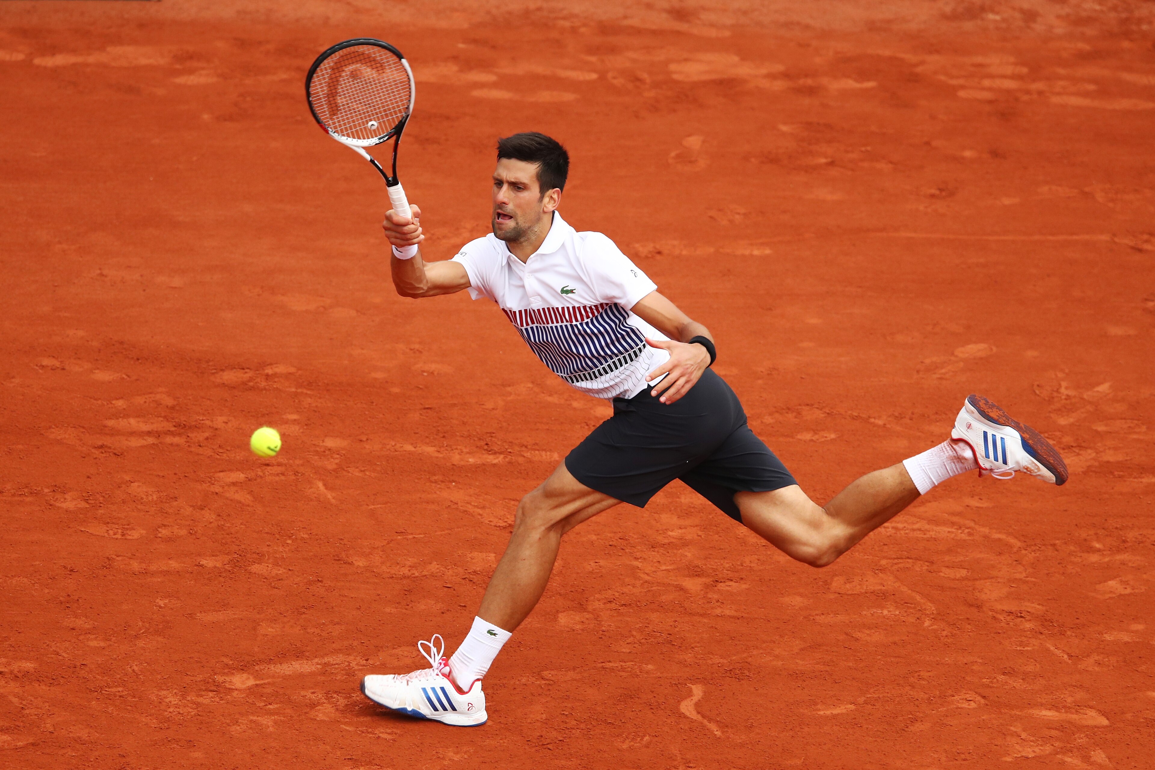 PARIS, FRANCE - JUNE 02:  Novak Djokovic of Serbia stretches to hit a forehand during the men's singles third round match against Diego Schwartzman of Argentina on day six of the 2017 French Open at Roland Garros on June 2, 2017 in Paris, France.  (Photo by Clive Brunskill/Getty Images)