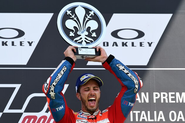 Ducati's rider Italian Andrea Dovizioso celebrates on the podium after winning the Moto GP Grand Prix at the Mugello race track on June 4, 2017. 
Ducati's Andrea Dovizioso thrilled the home crowds with a stirring MotoGP victory at Mugello on Sunday that saw him edge championship leader Maverick Vinales.
Another Italian, Danilo Petrucci, was third while veteran superstar Valentino Rossi of Yamaha won plaudits for racing in pain from a training accident and finishing fourth having set the early pace.
 / AFP PHOTO / Vincenzo PINTO        (Photo credit should read VINCENZO PINTO/AFP/Getty Images)