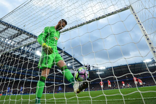 Manchester United's Spanish goalkeeper David de Gea retrieves the ball after Chelsea's Belgian midfielder Eden Hazard scored Chelsea's third goal during the English Premier League football match between Chelsea and Manchester United at Stamford Bridge in London on October 23, 2016. / AFP / GLYN KIRK / RESTRICTED TO EDITORIAL USE. No use with unauthorized audio, video, data, fixture lists, club/league logos or 'live' services. Online in-match use limited to 75 images, no video emulation. No use in betting, games or single club/league/player publications.  /         (Photo credit should read GLYN KIRK/AFP/Getty Images)