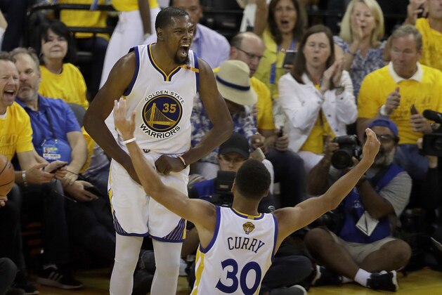 Golden State Warriors forward Kevin Durant (35) celebrates with guard Stephen Curry (30) during the second half of Game 2 of basketball's NBA Finals against the Cleveland Cavaliers in Oakland, Calif., Sunday, June 4, 2017. (AP Photo/Marcio Jose Sanchez)