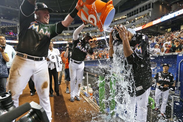Miami Marlins' Justin Bour, left, and Marcell Ozuna, center rear, pour ice and water onto starting pitcher Edinson Volquez, right, after the Marlins defeated the Arizona Diamondbacks 3-0 in a no-hitter by Volquez during a baseball game, Saturday, June 3, 2017, in Miami. (AP Photo/Wilfredo Lee)
