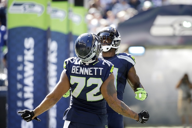 Seattle Seahawks' Kam Chancellor, right, is greeted by Michael Bennett (72) during player introductions before an NFL football game against the Chicago Bears, Sunday, Sept. 27, 2015, in Seattle. (AP Photo/Elaine Thompson)