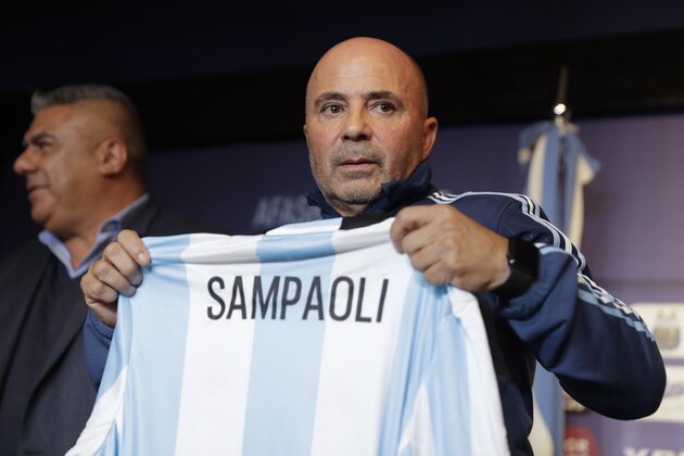 Argentina's new soccer coach Jorge Sampaoli holds up a jersey featuring his name at the end of a press conference in Buenos Aires, Argentina, Thursday, June 1, 2017. (AP Photo/Natacha Pisarenko)