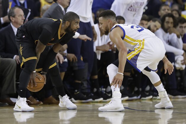 Cleveland Cavaliers guard Kyrie Irving, left, faces Golden State Warriors guard Stephen Curry during the first half of Game 2 of basketball's NBA Finals in Oakland, Calif., Sunday, June 4, 2017. (AP Photo/Marcio Jose Sanchez)