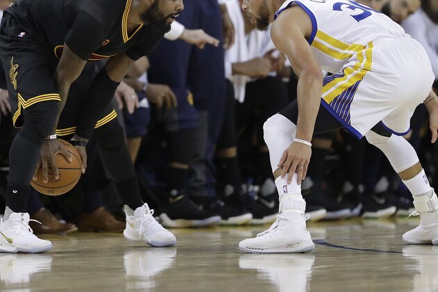 Cleveland Cavaliers guard Kyrie Irving, left, faces Golden State Warriors guard Stephen Curry during the first half of Game 2 of basketball's NBA Finals in Oakland, Calif., Sunday, June 4, 2017. (AP Photo/Marcio Jose Sanchez)