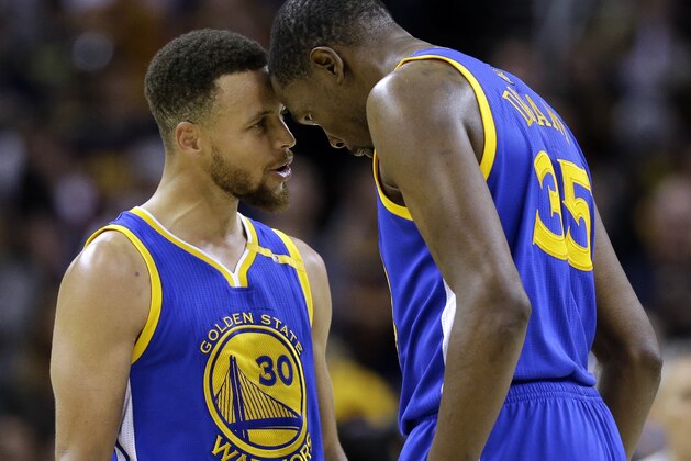 Golden State Warriors' Stephen Curry, left, and Kevin Durant talk in the final moments against the Cleveland Cavaliers in Game 3 of basketball's NBA Finals in Cleveland, Wednesday, June 7, 2017. Golden State won 118-113. (AP Photo/Tony Dejak)