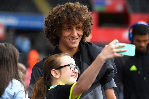 SWANSEA, WALES - SEPTEMBER 11:  David Luiz of Chelsea poses for selfie photographs with fans prior to the Premier League match between Swansea City and Chelsea at Liberty Stadium on September 11, 2016 in Swansea, Wales.  (Photo by Stu Forster/Getty Images)