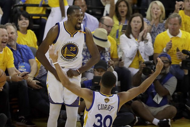 Golden State Warriors forward Kevin Durant (35) celebrates with guard Stephen Curry (30) during the second half of Game 2 of basketball's NBA Finals against the Cleveland Cavaliers in Oakland, Calif., Sunday, June 4, 2017. (AP Photo/Marcio Jose Sanchez)