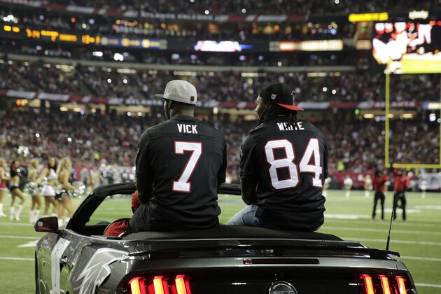 Former Atlanta Falcons players Roddy White, right, and Michael Vick are seen during halftime of an NFL football game between the Atlanta Falcons and the New Orleans Saints, Sunday, Jan. 1, 2017, in Atlanta. (AP Photo/David Goldman)