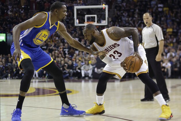 Golden State Warriors forward Kevin Durant (35) defends Cleveland Cavaliers forward LeBron James (23) diromg the first half of Game 4 of basketball's NBA Finals in Cleveland, Friday, June 9, 2017. (AP Photo/Tony Dejak)