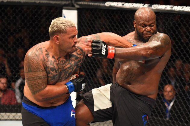 AUCKLAND, NEW ZEALAND - JUNE 11:  (L-R) Mark Hunt of New Zealand punches Derrick Lewis in their heavyweight fight during the UFC Fight Night event at the Spark Arena on June 11, 2017 in Auckland, New Zealand. (Photo by Josh Hedges/Zuffa LLC/Zuffa LLC via Getty Images)