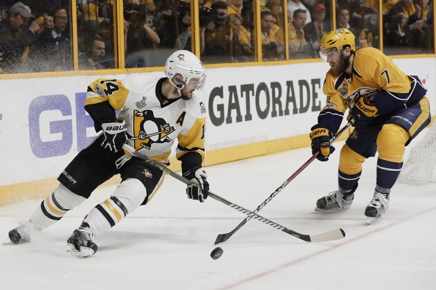 Nashville Predators defenseman Yannick Weber (7), of Switzerland, knocks the puck from Pittsburgh Penguins left wing Chris Kunitz (14) during the second period in Game 4 of the NHL hockey Stanley Cup Finals Monday, June 5, 2017, in Nashville, Tenn. (AP Photo/Mark Humphrey)
