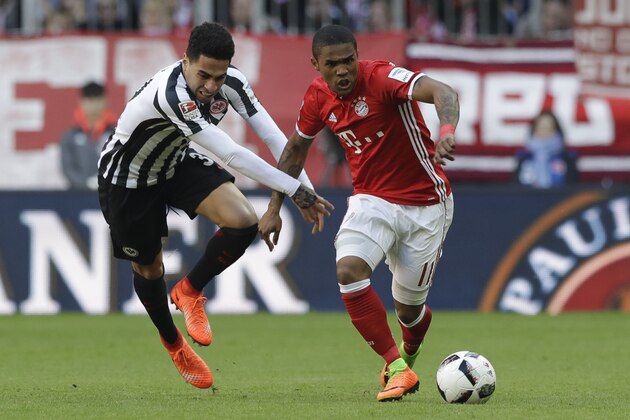 Frankfurt's Omar Mascarell, left, and Bayern's Douglas Costa challenge for the ball during the German Soccer Bundesliga match between FC Bayern Munich and Eintracht Frankfurt at the Allianz Arena stadium in Munich, Germany, Saturday, March 11, 2017. (AP Photo/Matthias Schrader)