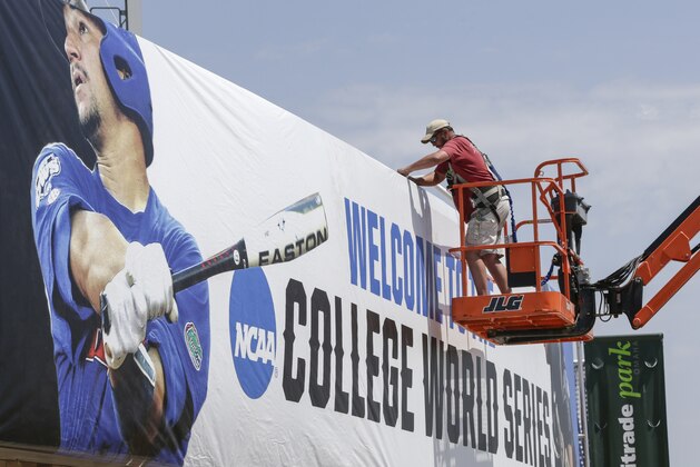 Bryan Hartley, an employee of Sport Graphics in Indianapolis, works on a large banner welcoming fans to the College World Series, Thursday, June 8, 2017, in Omaha, Neb. Preparations for the NCAA College World Series Baseball tournament continue at TD Ameritrade Park in Omaha. (AP Photo/Nati Harnik)
