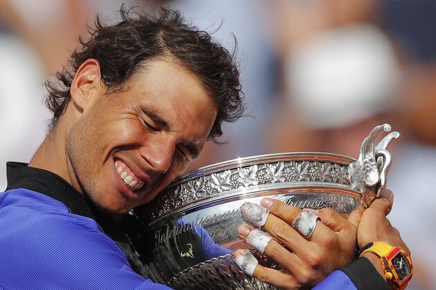Spain's Rafael Nadal holds the trophy as he celebrates winning his tenth French Open title against Switzerland's Stan Wawrinka in three sets, 6-2, 6-3, 6-1, during their men's final match of the French Open tennis tournament at the Roland Garros stadium, in Paris, France, Sunday, June 11, 2017. (AP Photo/Christophe Ena)