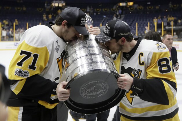 Pittsburgh Penguins' Evgeni Malkin (71), of Russia, and Sidney Crosby (87) kiss the Stanley Cup after defeating the Nashville Predators 2-0 in Game 6 of the NHL hockey Stanley Cup Final, Sunday, June 11, 2017, in Nashville, Tenn. (AP Photo/Mark Humphrey)