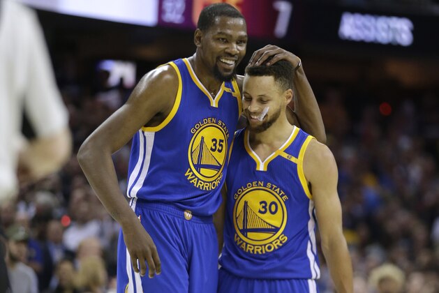 Golden State Warriors' Kevin Durant (35) hugs teammate Stephen Curry (30) during the first half of Game 4 of basketball's NBA Finals against the Cleveland Cavaliers in Cleveland, Friday, June 9, 2017. (AP Photo/Tony Dejak)