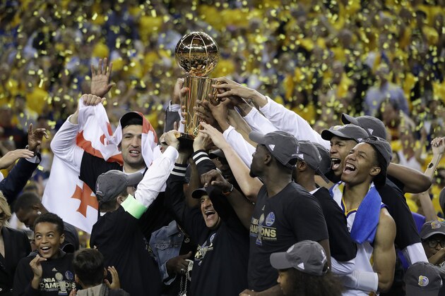 Golden State Warriors players, coaches and owners hold up the Larry O'Brien NBA Championship Trophy after Game 5 of basketball's NBA Finals between the Warriors and the Cleveland Cavaliers in Oakland, Calif., Monday, June 12, 2017. The Warriors won 129-120 to win the NBA championship. (AP Photo/Marcio Jose Sanchez)