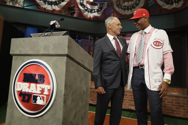 Hunter Greene, right, a pitcher and shortstop from Notre Dame High School in Sherman Oaks, Calif., talks to commissioner Rob Manfred after being selected No. 2 by the Cincinnati Reds in the first round of the Major League Baseball draft, Monday, June 12, 2017, in Secaucus, N.J.(AP Photo/Julio Cortez)