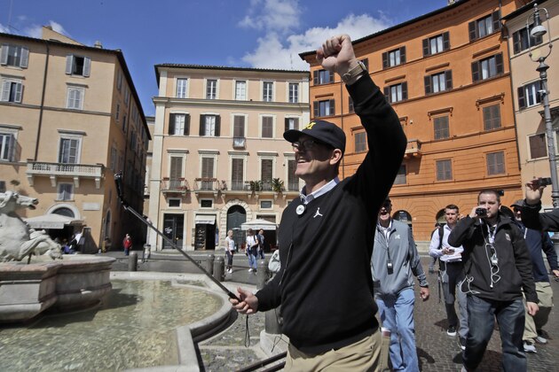 Michigan football team coach Jim Harbaugh, visits Piazza Navona Square in Rome, Monday, April 24, 2017. Michigan's football team arrived in Rome this weekend and kicked off the unique trip by meeting with refugees before going to the Vatican for a Papal address and practicing a few times. (AP Photo/Alessandra Tarantino)