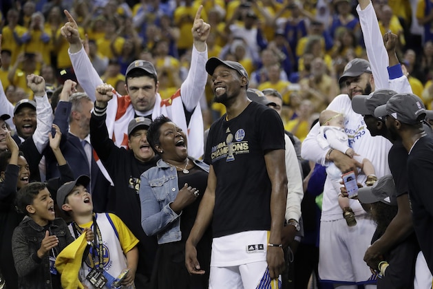Golden State Warriors forward Kevin Durant, center, celebrates with his mother Wanda Durant as he is named the NBA Finals Most Valuable Player after Game 5 of basketball's NBA Finals between the Warriors and the Cleveland Cavaliers in Oakland, Calif., Monday, June 12, 2017. The Warriors won 129-120 to win the NBA championship. (AP Photo/Marcio Jose Sanchez)