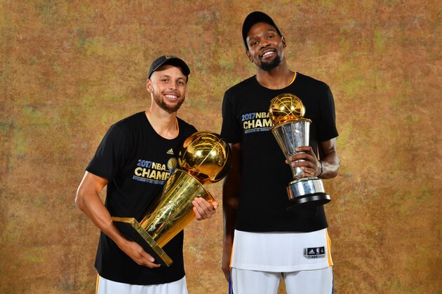 OAKLAND, CA - JUNE 12: Stephen Curry and Kevin Durant of the Golden State Warriors poses for a portrait with the Larry O'Brien Trophy after defeating the Cleveland Cavaliers in Game Five of the 2017 NBA Finals on June 12, 2017 at ORACLE Arena in Oakland, California. NOTE TO USER: User expressly acknowledges and agrees that, by downloading and or using this photograph, User is consenting to the terms and conditions of the Getty Images License Agreement. Mandatory Copyright Notice: Copyright 2017 NBAE (Photo by Jesse D. Garrabrant/NBAE via Getty Images)