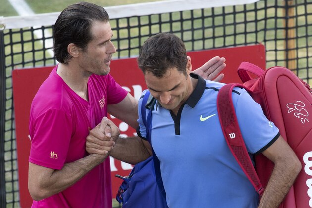 Switzerland's Roger Federer (R) is comforted by Germany's Tommy Haas after he lost in their round of sixteen match at the ATP Cup tennis tournament in Stuttgart, southwestern Germany, on June 14, 2017.   / AFP PHOTO / THOMAS KIENZLE        (Photo credit should read THOMAS KIENZLE/AFP/Getty Images)