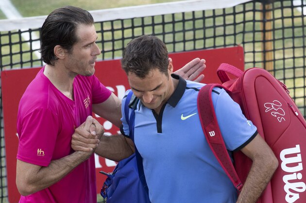Switzerland's Roger Federer (R) is comforted by Germany's Tommy Haas after he lost in their round of sixteen match at the ATP Cup tennis tournament in Stuttgart, southwestern Germany, on June 14, 2017.   / AFP PHOTO / THOMAS KIENZLE        (Photo credit should read THOMAS KIENZLE/AFP/Getty Images)