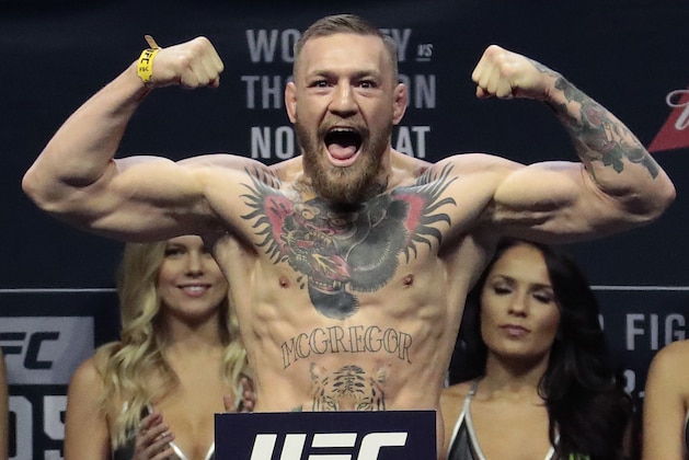 FILE - In this Nov. 11, 2016, file photo, Conor McGregor stands on a scale during the weigh-in event for his fight against Eddie Alvarez in UFC 205 mixed martial arts at Madison Square Garden in New York.  Floyd Mayweather Jr. says facing UFC star McGregor in a boxing ring