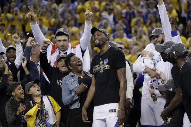Golden State Warriors forward Kevin Durant, center, celebrates with his mother Wanda Durant as he is named the NBA Finals Most Valuable Player after Game 5 of basketball's NBA Finals between the Warriors and the Cleveland Cavaliers in Oakland, Calif., Monday, June 12, 2017. The Warriors won 129-120 to win the NBA championship. (AP Photo/Marcio Jose Sanchez)