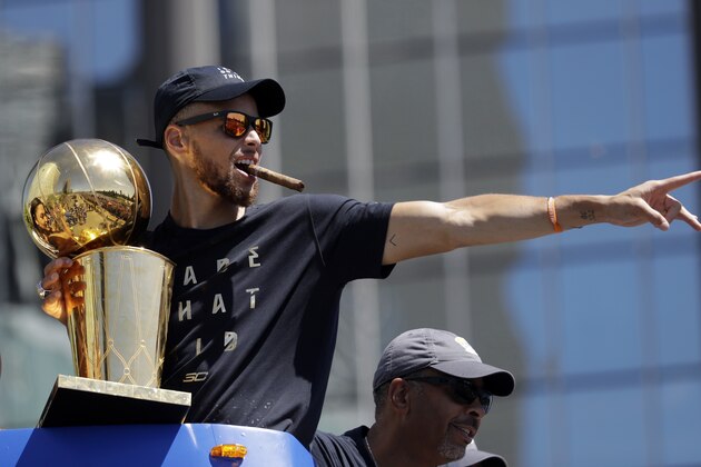 Golden State Warriors' Stephen Curry with the Larry O'Brien trophy during a parade and rally after winning the NBA basketball championship Thursday, June 15, 2017, in Oakland, Calif. (AP Photo/Marcio Jose Sanchez)